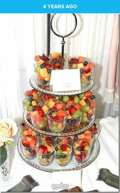 a tiered tray filled with fruit on top of a table