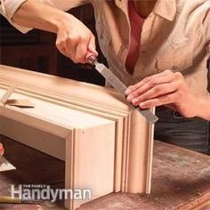 a woman is using a pair of scissors to cut out the top of a cabinet