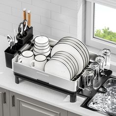 a dish rack with dishes and utensils in it