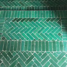 a green tiled floor with two rows of tiles on top of each other and one row of