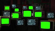 several televisions with green screens in front of them