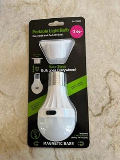 a white light bulb in its packaging on a marble counter top with the tag attached to it