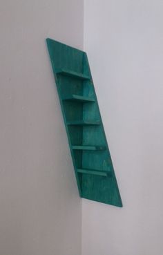 a green shelf mounted to the side of a white wall