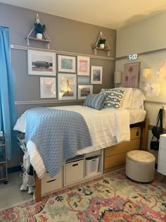 a bedroom with a bed, dressers and pictures on the wall