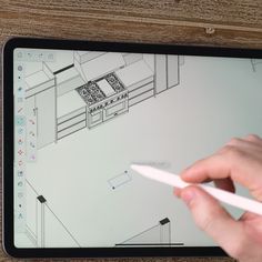 a person is drawing on a tablet with a pen in their left hand and the other hand pointing at it