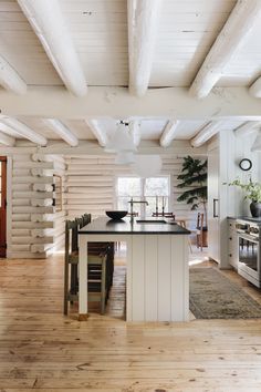 a kitchen with white walls and wooden floors