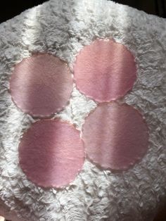 four pink and white circles are on the back of a stuffed animal