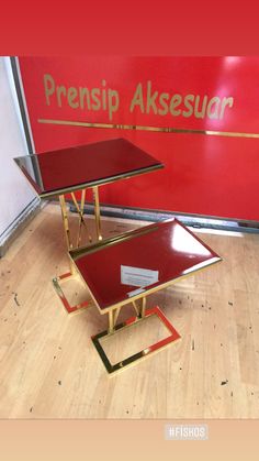 two tables sitting on top of each other in front of a red sign that says prensip akesuar