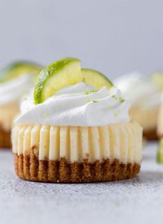 several small desserts with lime slices and whipped cream on top, sitting next to each other