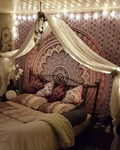 a bed with a canopy over it and some lights on the headboard above it