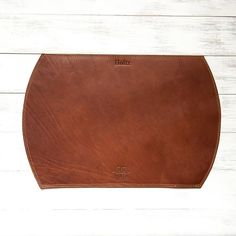 a brown leather pouch sitting on top of a white wooden floor