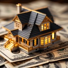 a house sitting on top of money with the light shining from it's windows