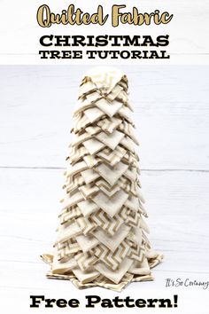 a christmas tree made out of fabric sitting on top of a white wooden table with text overlay that reads, quilted fabric christmas tree pattern