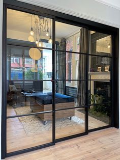 a living room with large glass doors that open up to the dining area and outside