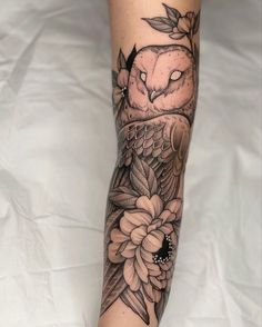 an owl and flower tattoo on the leg