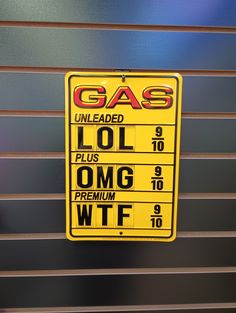 a yellow gas station sign hanging from the side of a garage door that reads,