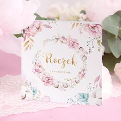 a white card with pink flowers on it and the word rozek in gold lettering