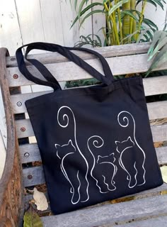 a black bag sitting on top of a wooden bench next to a potted plant