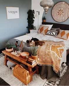 a bed room with a neatly made bed and some plants on the table next to it