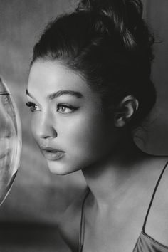 a black and white photo of a woman holding a wine glass in front of her face