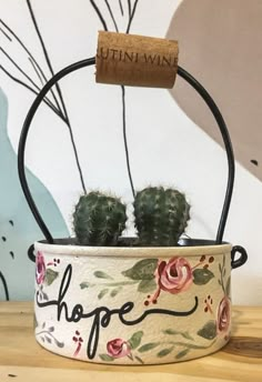 a potted plant with two small cactuses in it on a table next to a wine cork holder