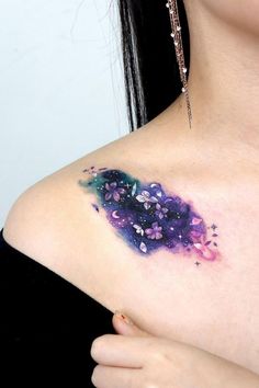 a woman's chest with purple and blue paint splattered on the breast