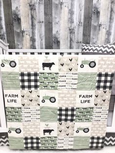 a black and white quilt with farm life written on the front, along with an image of a cow