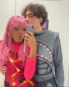 a man taking a selfie with a woman in front of him wearing pink wig