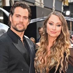 a man and woman standing next to each other in front of a camera on the red carpet