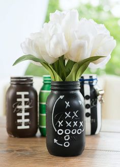 some white flowers are in a black mason jar