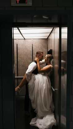 a bride and groom kissing in an elevator