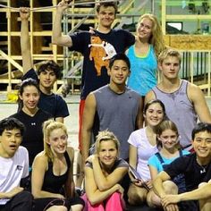 a group of young people posing for a photo in front of a construction site with scaffolding