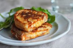 two grilled cheese sandwiches on a white plate