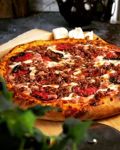 a pizza sitting on top of a wooden cutting board