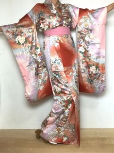 A woman's long sleeve Furisode Kimono. Sash sold separately. Japanese vintage dress with butterfly & floral pattern in metallic gold, coral and seashell colors. Fits a USA size S. International Express Shipping includedsee below) MATERIAL: Silky synthetic.   PATTERN:  Flowers and Butterflies.   COLORS:  Toasted coral orange, seashell pink, blue and purple, sage and olive green.  DETAILS:  Metallic gold overlay on design.   CONDITION:  Used, vintage.  Good condition. Belt NOT included. Kimono Sas Butterfly Kimono, Vintage Floral Print Kimono, Vintage Long Sleeve Kimono, Vintage Long Sleeve Wedding Kimono, Vintage Fitted Kimono With Kimono Sleeves, Floral Print Long Sleeve Kimono For Wedding, Long Sleeve Floral Print Kimono For Wedding, Long Sleeve Floral Kimono For Wedding, Long Sleeve Floral Print Wedding Kimono