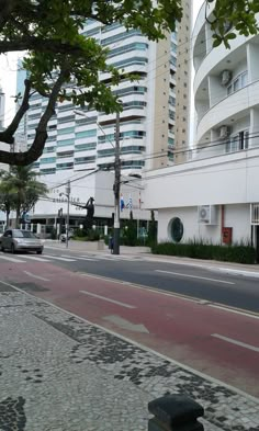 an empty city street with tall buildings in the background