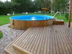 an above ground pool with steps leading up to it and a hot tub in the middle