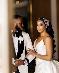 a bride and groom standing in front of a mirror