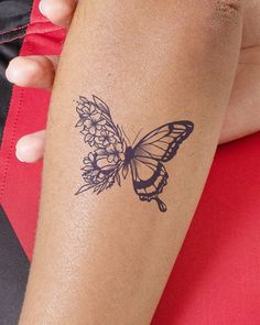 a woman's arm with a butterfly tattoo on the left side of her arm