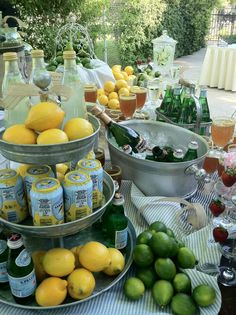 a table filled with lemons, limes and bottles of alcohol on top of it