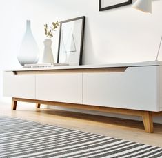 a white entertainment center with two vases on top