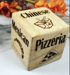 a wooden block with the word mexican pizza written on it and flowers in the background