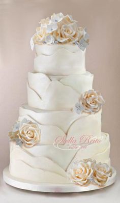 a three tiered wedding cake with flowers on top