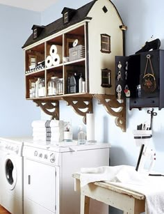 a washer and dryer sitting in a room next to a wall mounted shelf