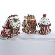 three small gingerbread houses are decorated with candy canes