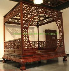 an ornate wooden bed in the middle of a room