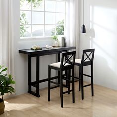 a table and two chairs in front of a window with plants on the windowsill