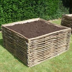 two wooden boxes filled with dirt sitting in the grass