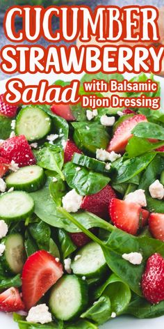 a salad with strawberries, cucumber and feta cheese on top in a white bowl