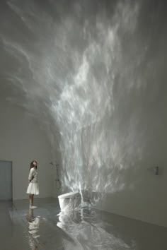 a woman standing in front of a white toilet covered in water and clouds above it